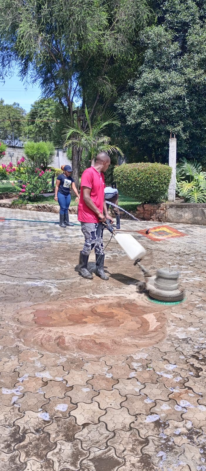 Twin Brothers technician using a rotary floor scrubber to deep-clean an outdoor paved patio
